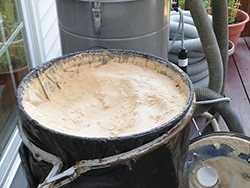 Full bin of dust from sanding a floor